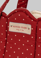 Close-up of Fraise Dot print showing deep berry red fabric with cream polka dots and Konges Sløjd label