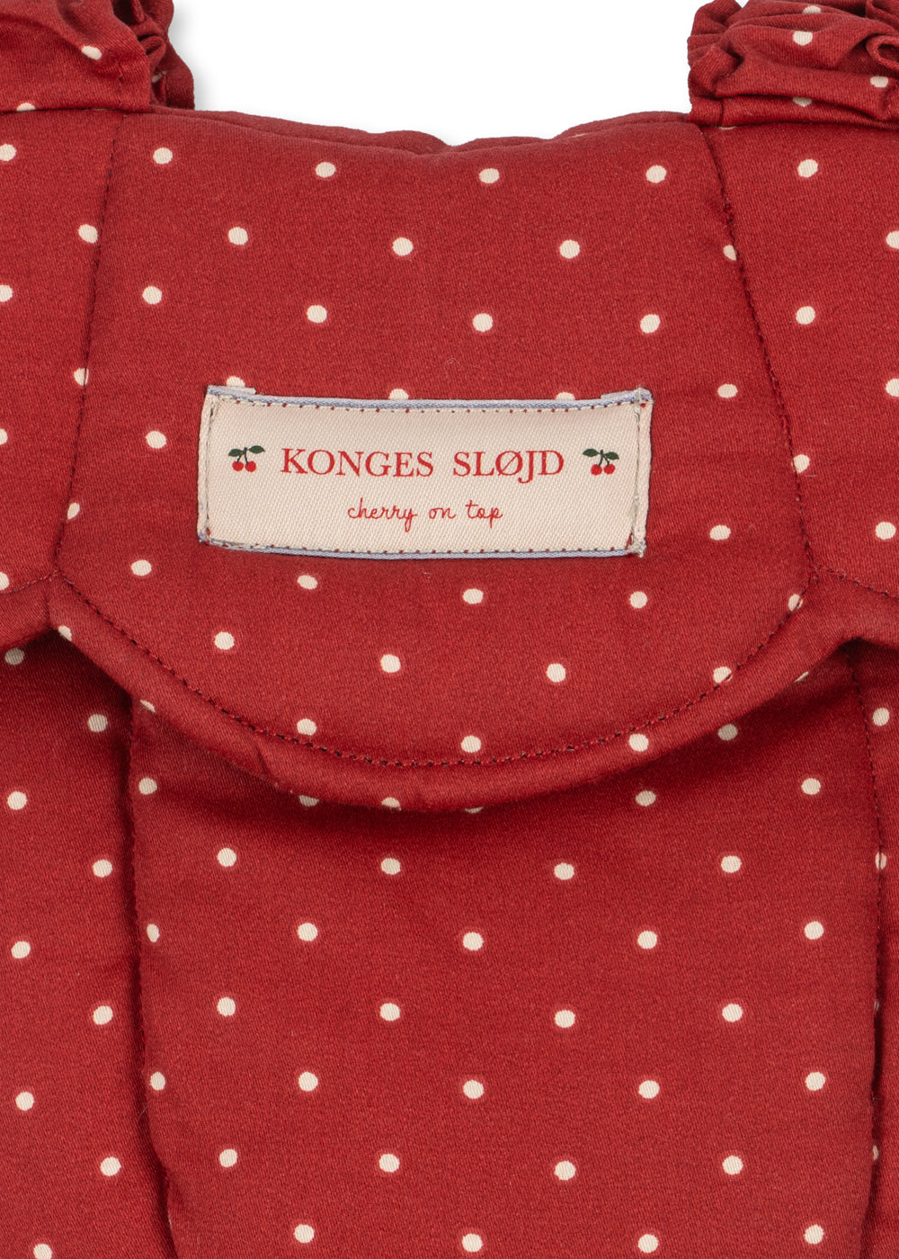 Close-up of Fraise Dot print on carrier showing deep berry red fabric with cream polka dots