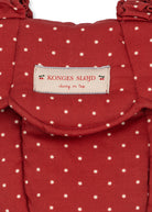 Close-up of Fraise Dot print on carrier showing deep berry red fabric with cream polka dots