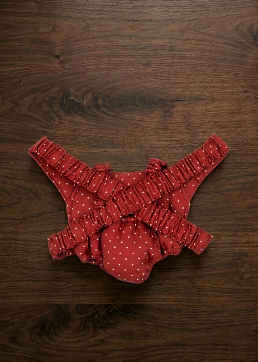 Back view of doll carrier showing adjustable elastic shoulder straps and quilted construction