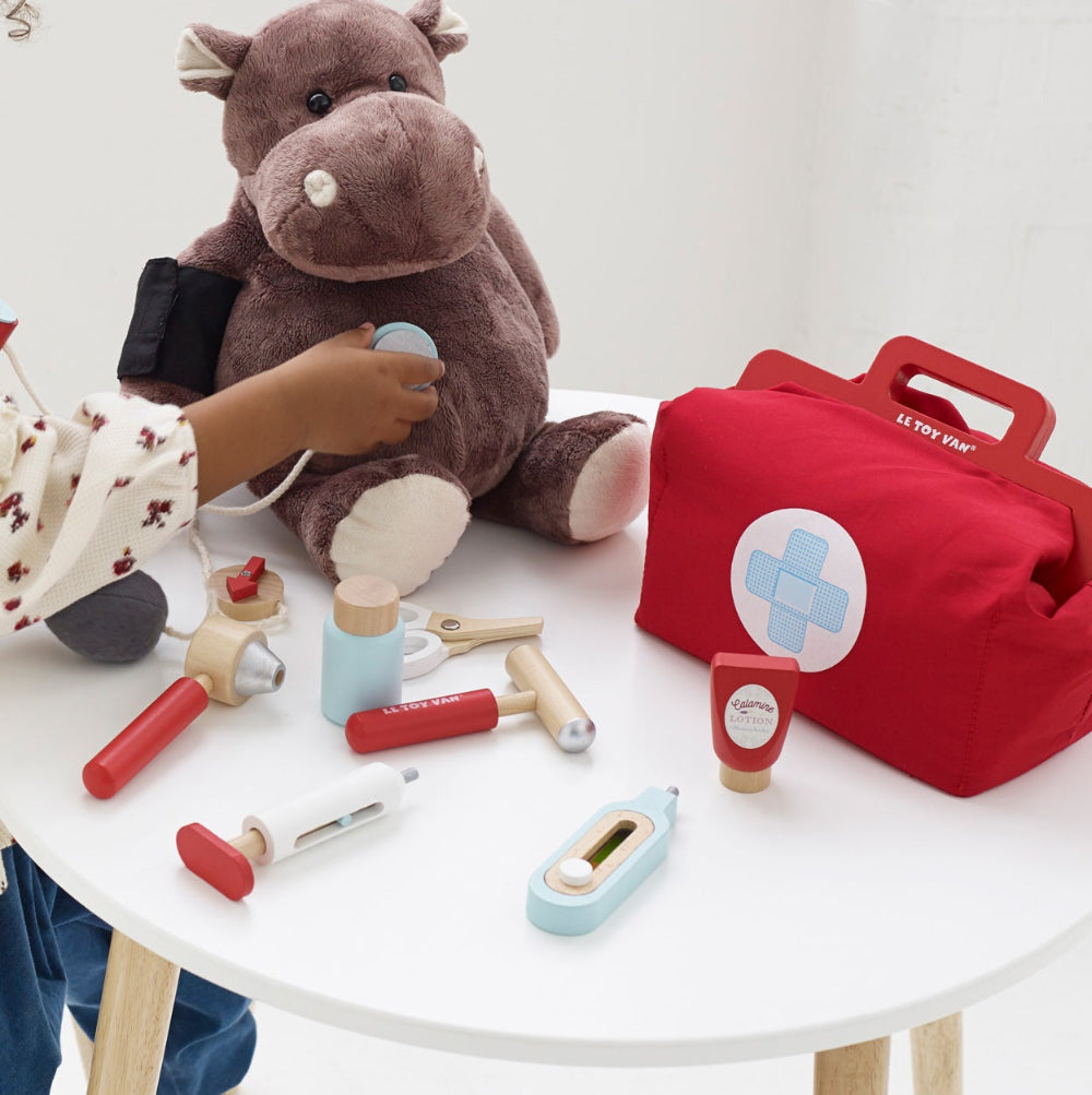 Child playing with Le Toy Van doctor kit during pretend medical care