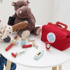 Child playing with Le Toy Van doctor kit during pretend medical care