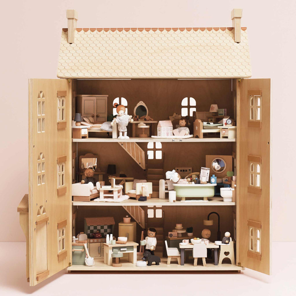 Detailed dollhouse with miniature furniture and accessories on a plain background