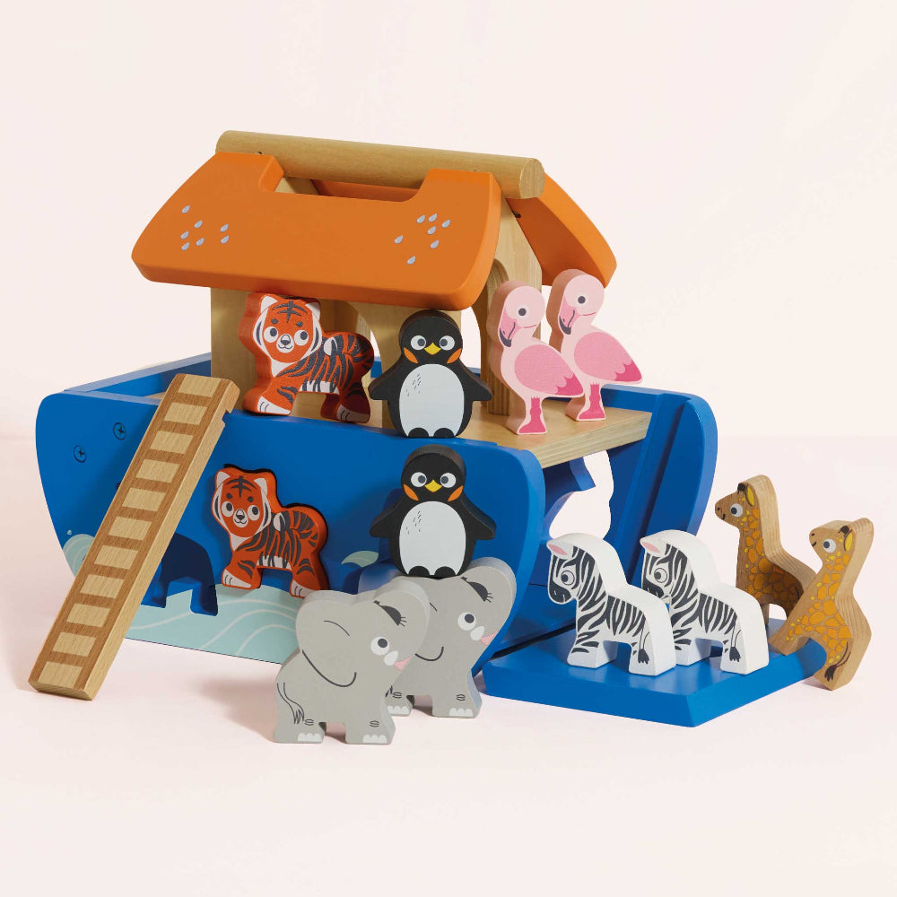 Wooden toy set with animal figures and a colorful playhouse on a light pink background