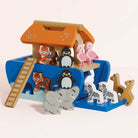 Wooden toy set with animal figures and a colorful playhouse on a light pink background
