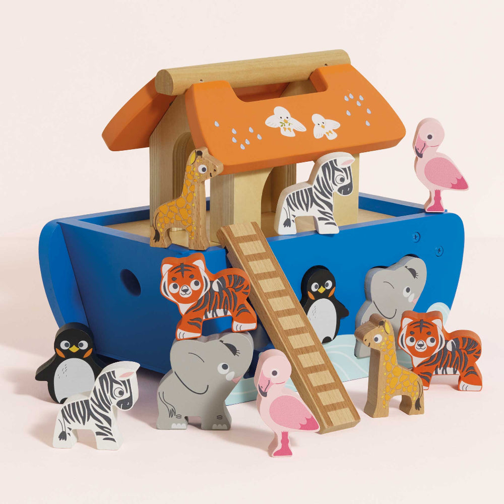 Wooden toy Noah's Ark with animal figures on a light pink background