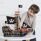 Child playing with Le Toy Van pirate ship during swashbuckling adventure
