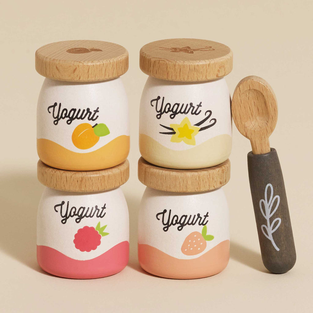 Four yogurt pots: apricot, vanilla, raspberry, strawberry
