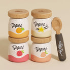 Four yogurt pots: apricot, vanilla, raspberry, strawberry