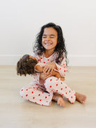 Toddler in blush pink heart print comfort wear showing stretchy movement and fit