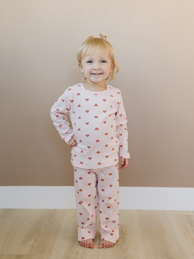 Toddler in sophisticated mauve heart print showing stretchy athletic fit