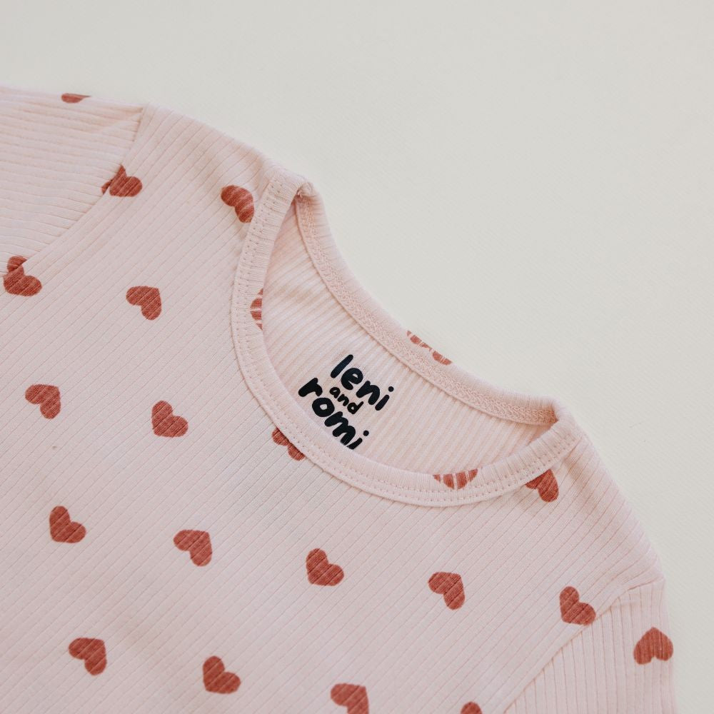 Detail of Leni & Romi tagless ribbed fabric with scattered mauve hearts design