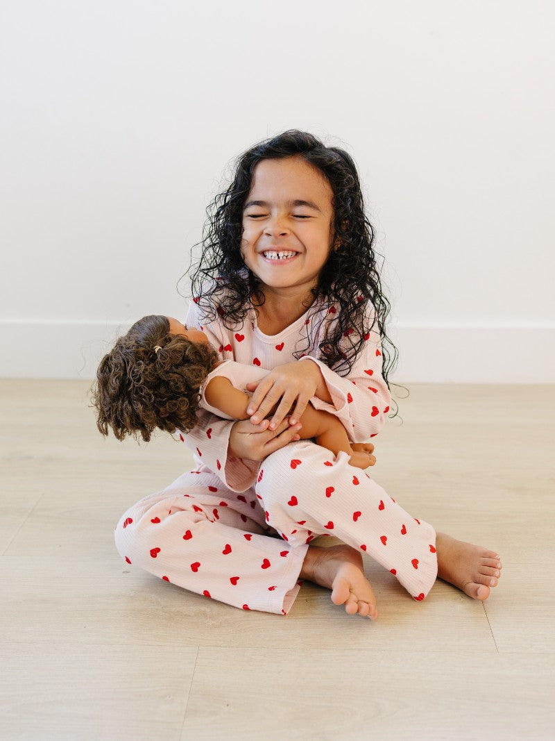Toddler in blush pink heart print comfort wear showing stretchy movement and fit