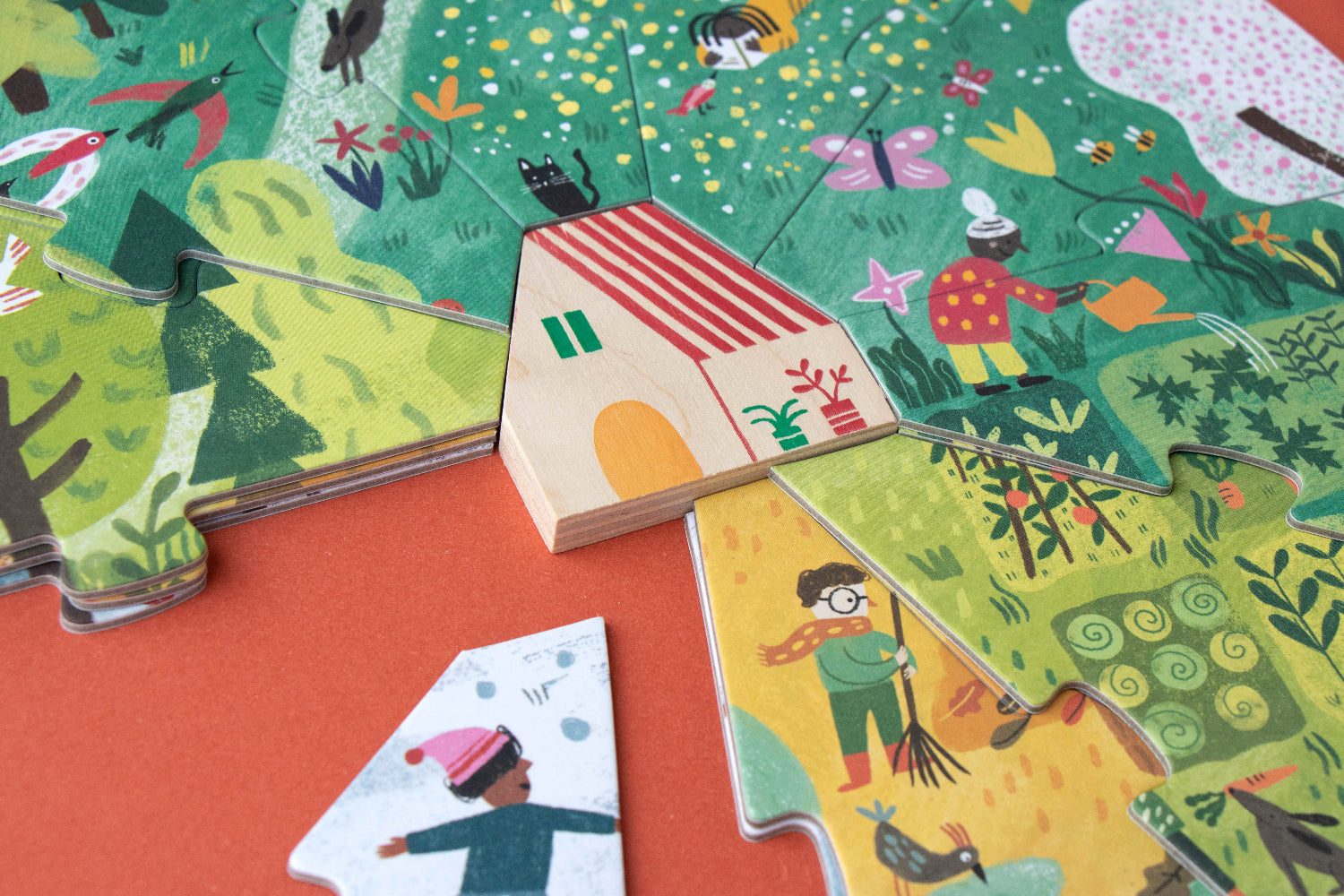 Children's puzzle with colorful illustrations of a house and people on a red surface