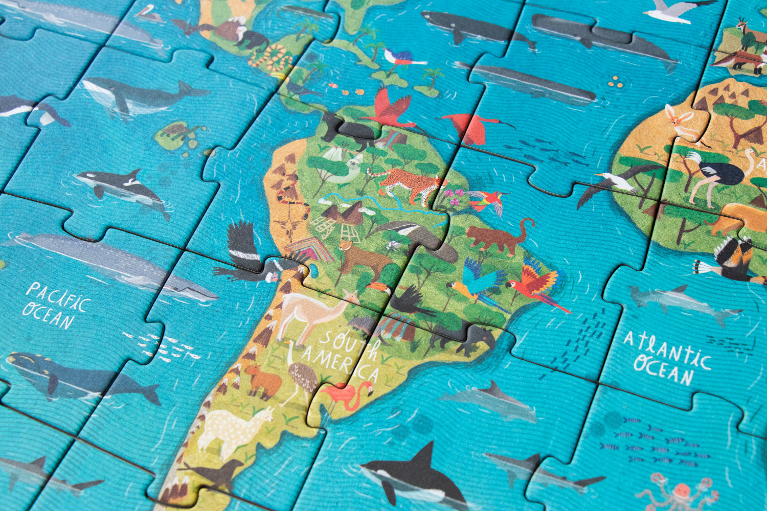 Children's puzzle with a map of the world and animals on a blue background
