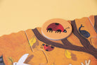 Wooden puzzle piece with a ladybug design on a yellow background