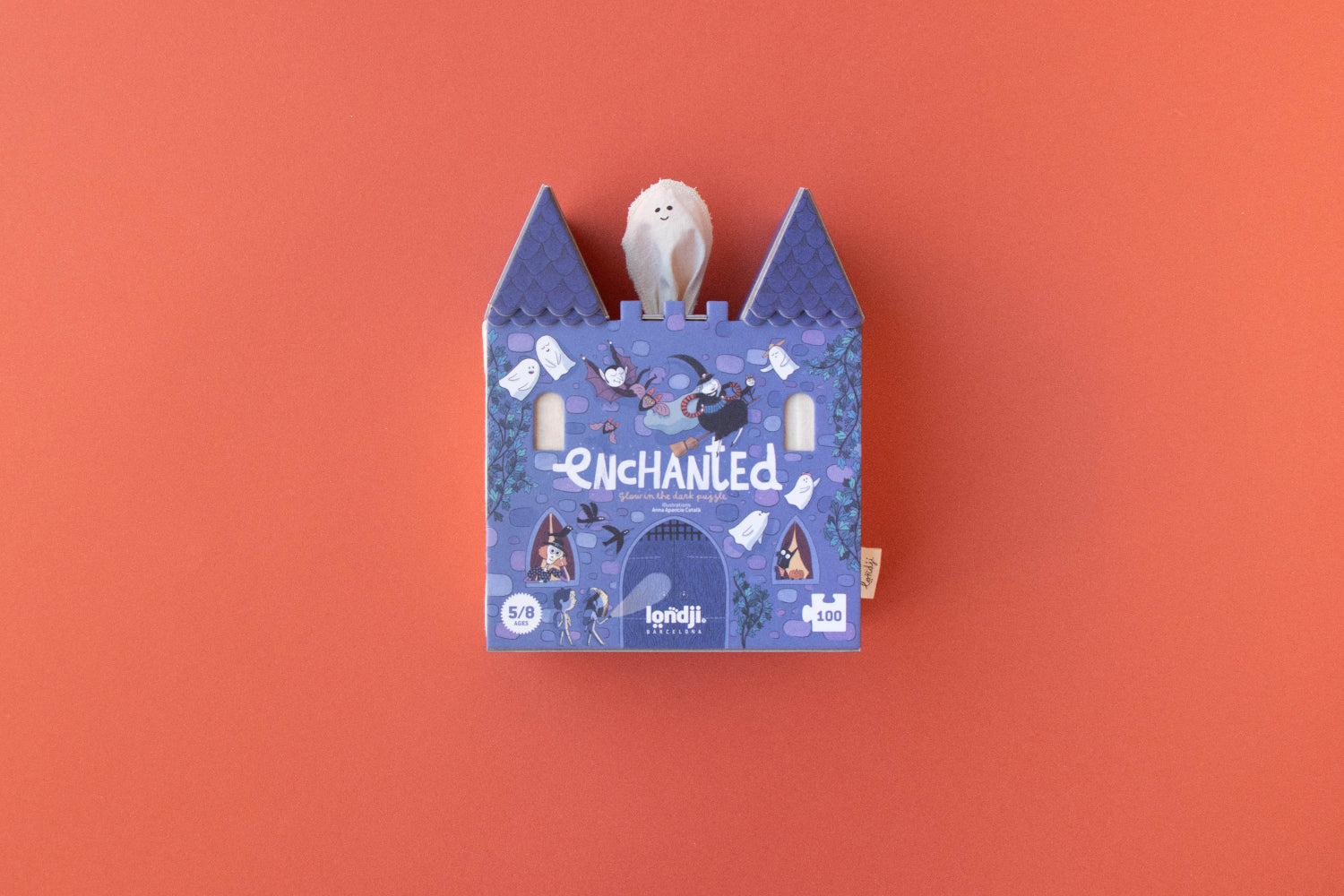 Blue castle-shaped box with a white plush toy on an orange background