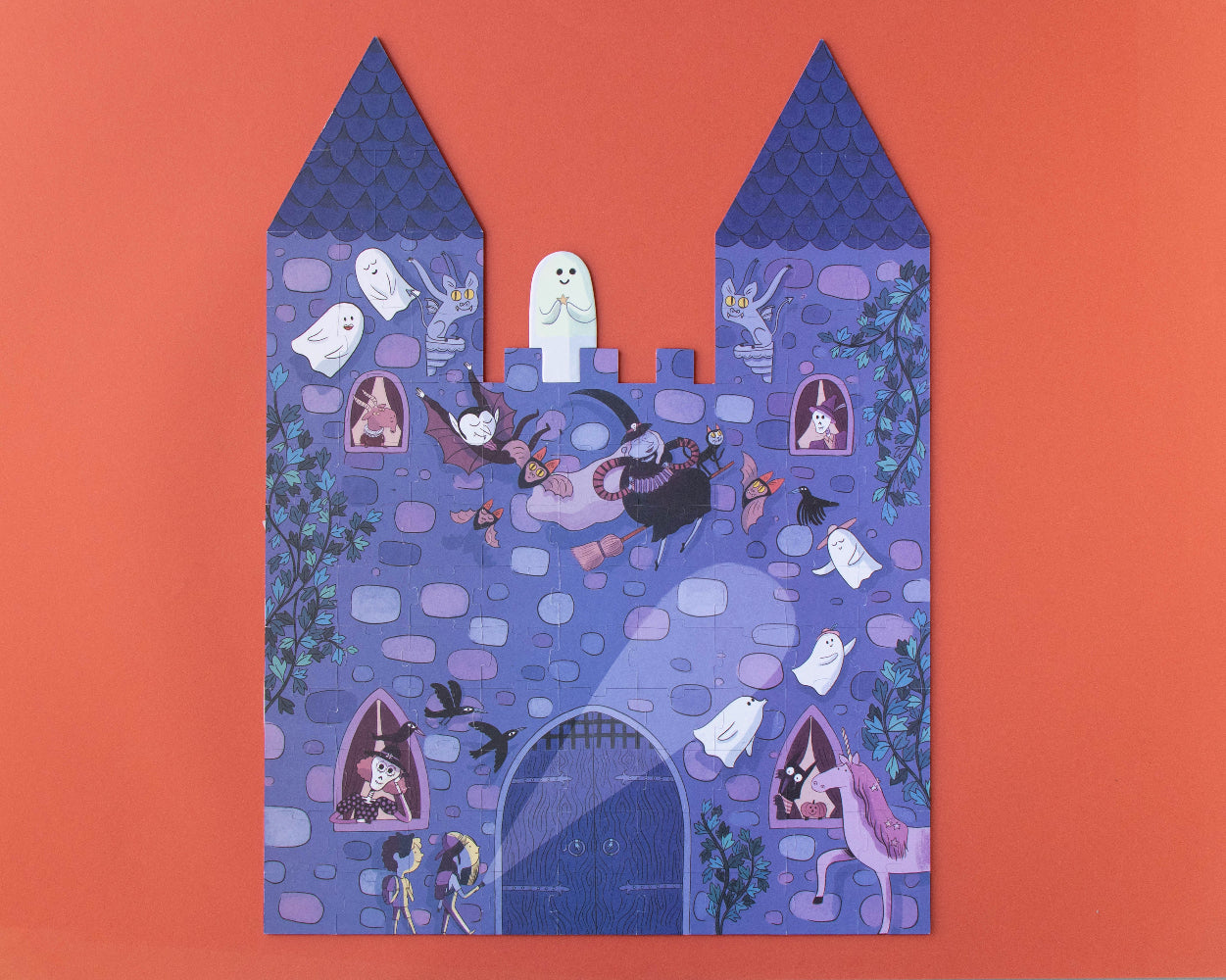 Decorative paper cutout of a haunted castle on an orange background