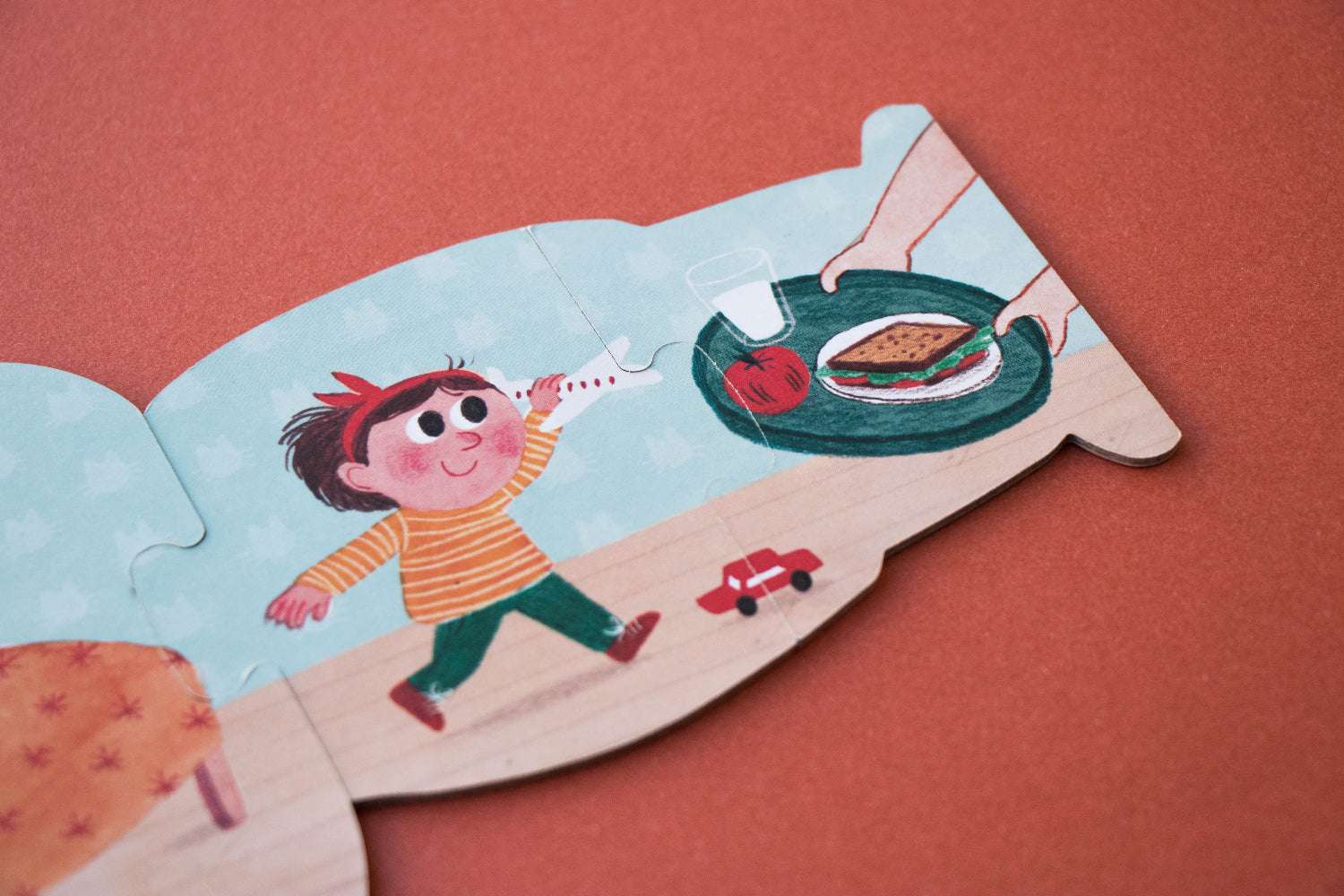 Children's puzzle piece with an illustration of a child and a hamburger on a red background