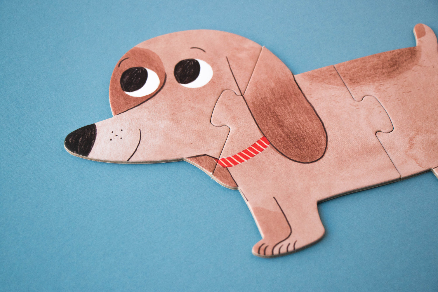 Dog-shaped paper puzzle on a blue background