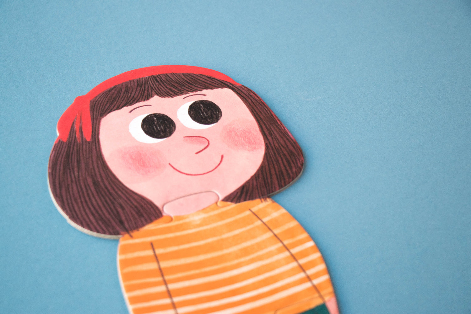 Colorful puzzle of a person with a red headband and orange striped shirt on a blue background