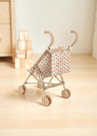 Full view of collapsible doll stroller in Lumina print with steel frame and wooden wheels