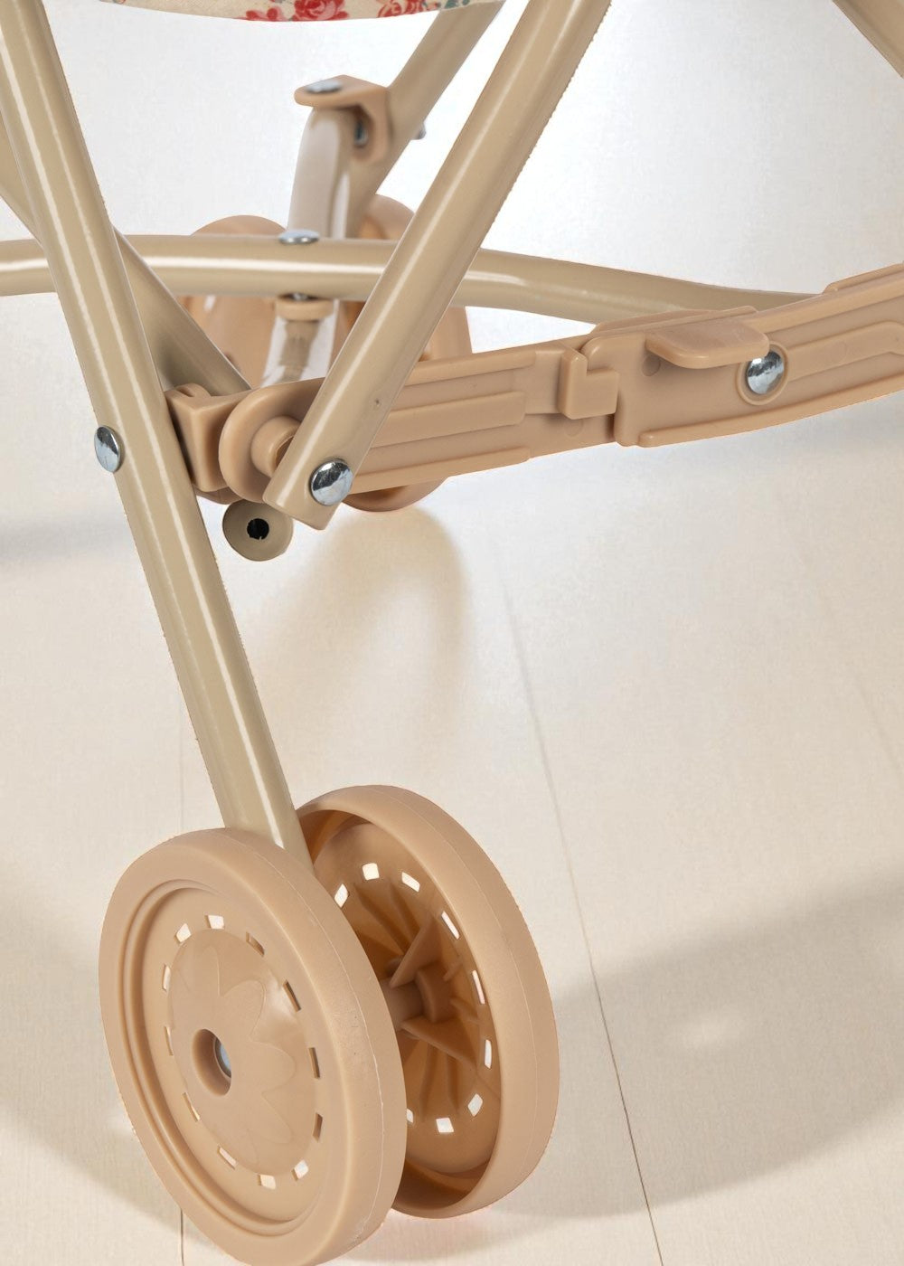 Detail of durable steel frame mechanism and smooth-rolling wooden wheel on toy stroller