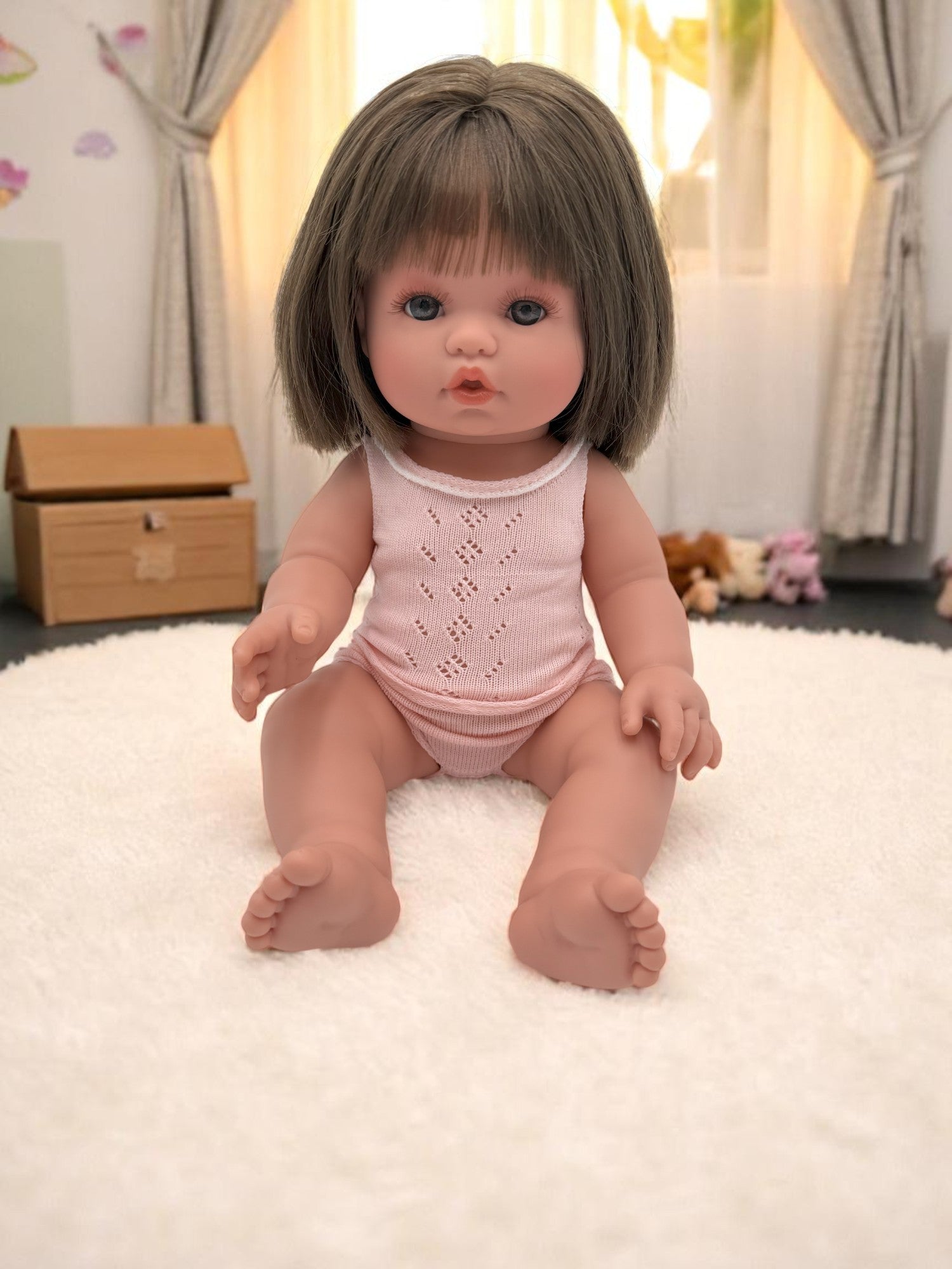 Milan realistic baby doll with straight brunette hair in pink pajamas for toddlers developmental play