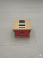 Compact coin sorting toy with pastel colored wooden coins ages 3 plus