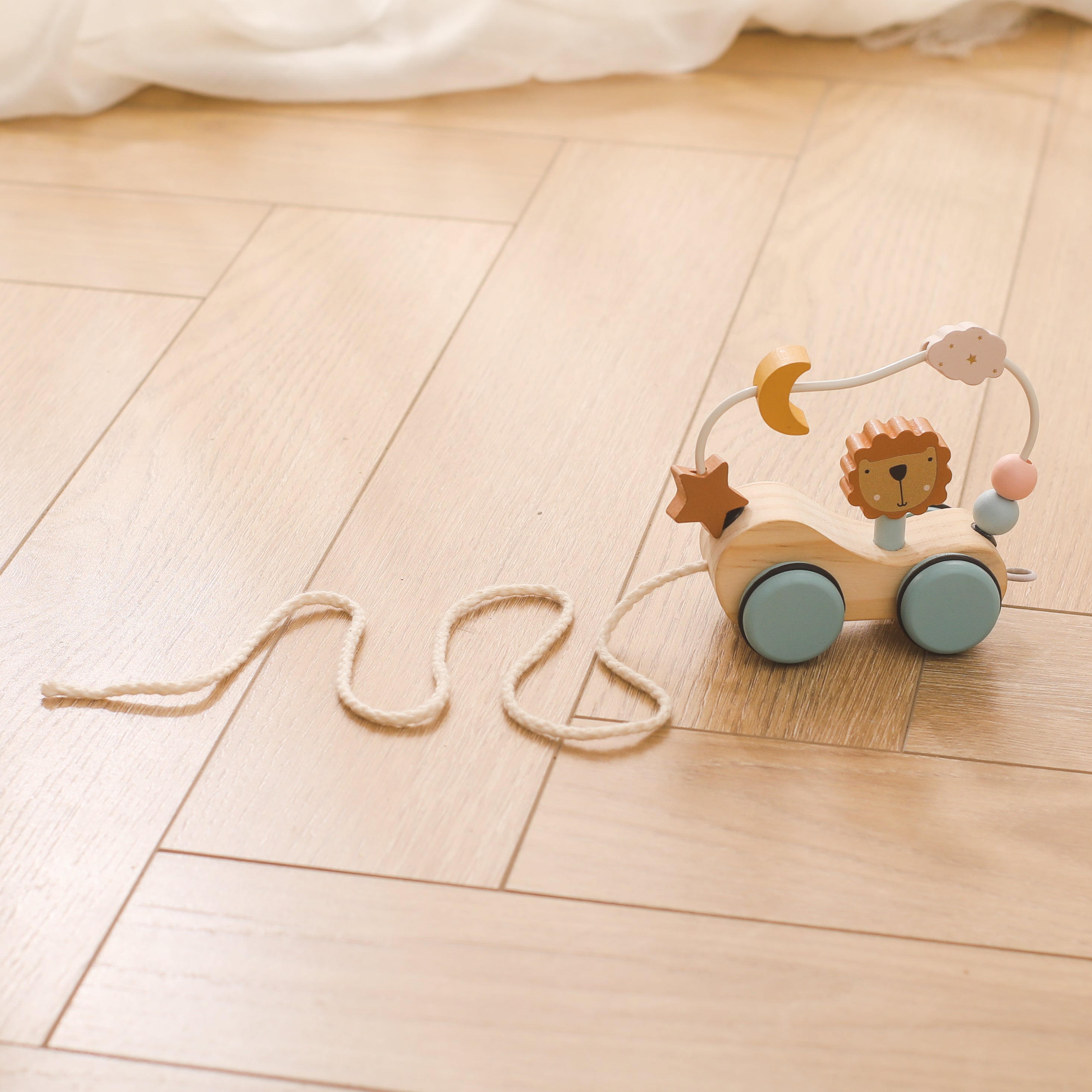 Close-up of wooden lion pull toy showing detailed craftsmanship and non-toxic pastel finishes