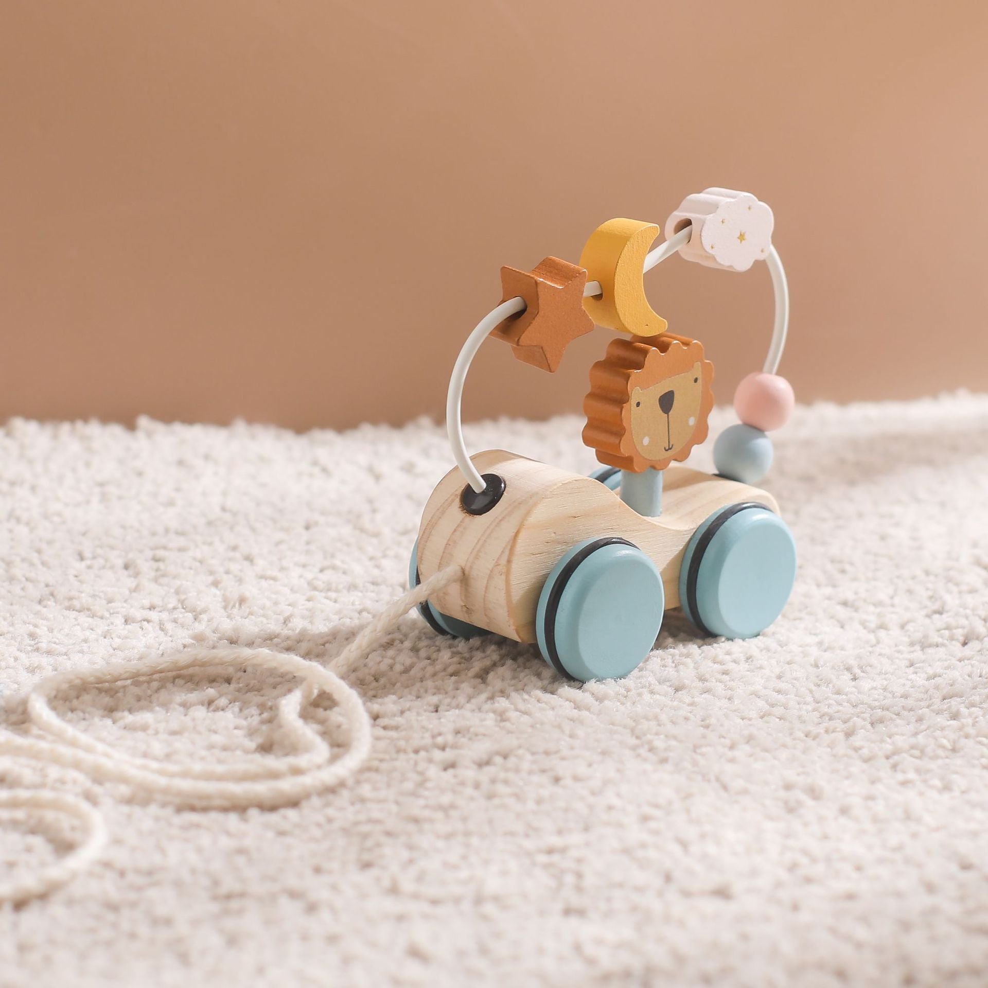 Natural wood pull toy featuring lion character with interactive bead path and celestial elements