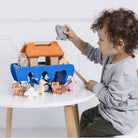 Child playing with a wooden toy set on a white table