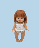 Doll with brown hair wearing a white outfit with red hearts on a light gray background