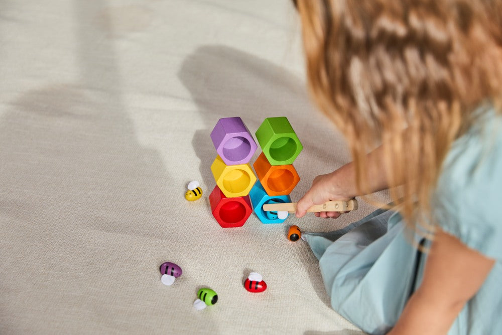 Child playing with colorful building blocks on a light surface