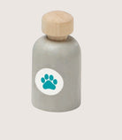Bottle with wooden cap and paw print label on a light gray background