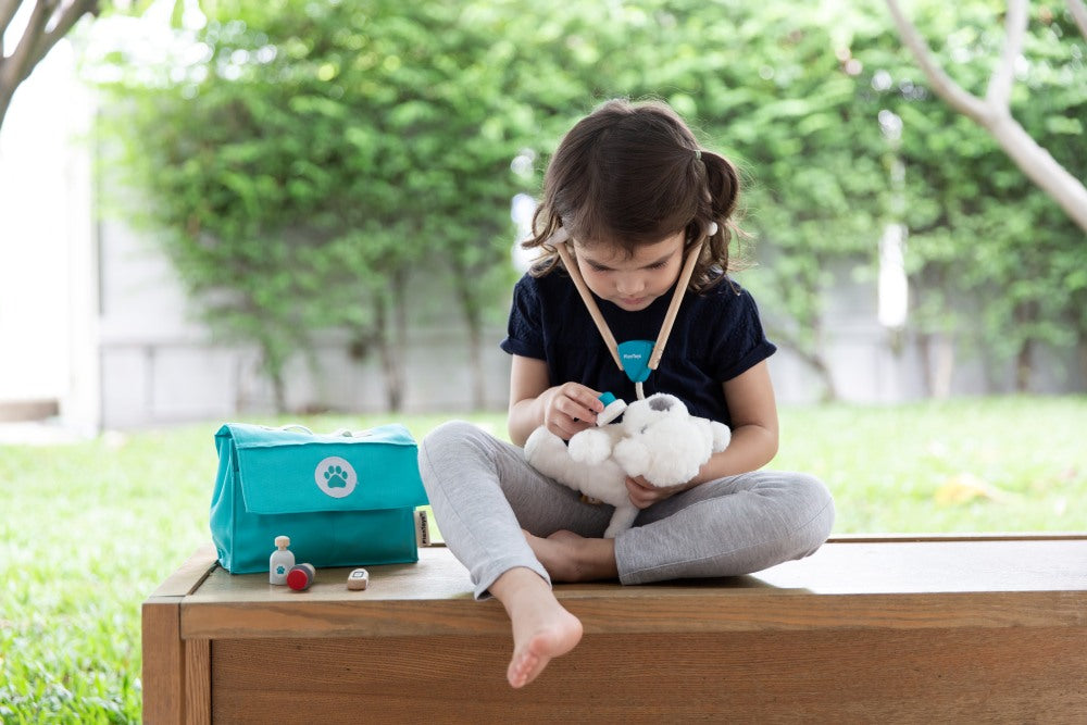 Child playing veterinarian with PlanToys wooden vet medical tools