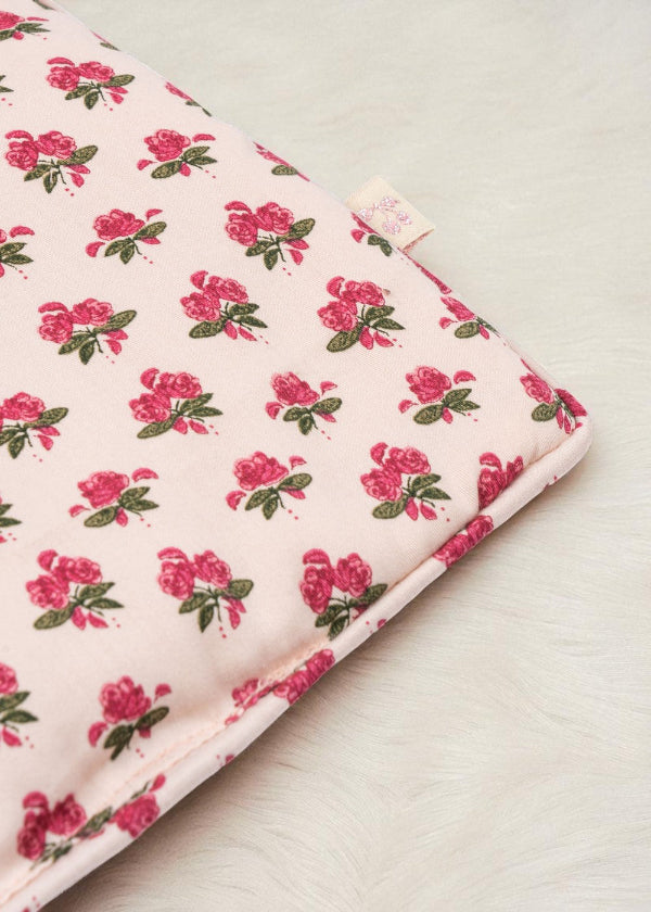 Close-up of Rosie Rose print fabric showing delicate pink roses with green leaves pattern and premium cotton texture with branded label