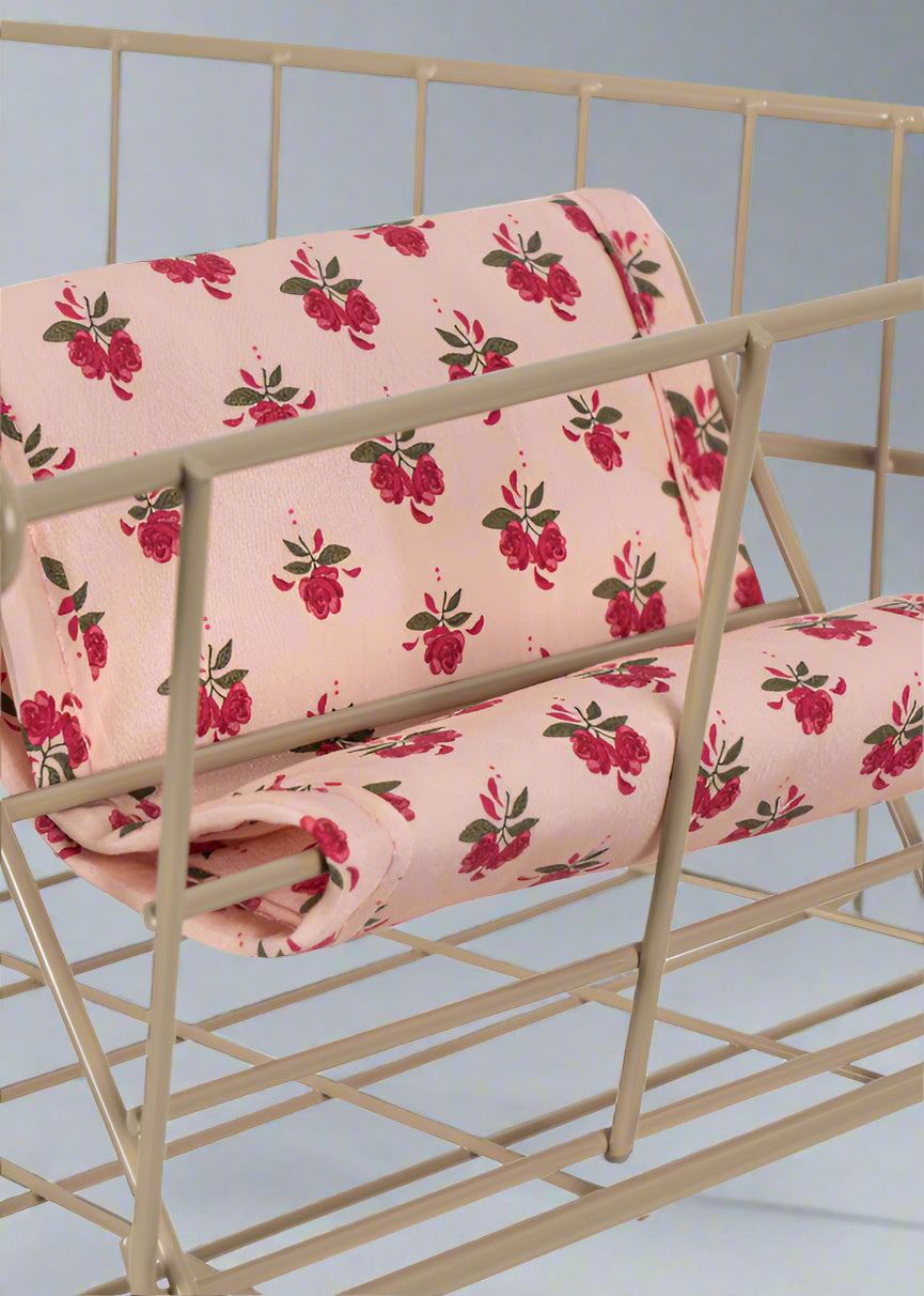 Close-up of Rosie Rose vintage print fabric featuring pink roses with green leaves on blush background with decorative tie closures