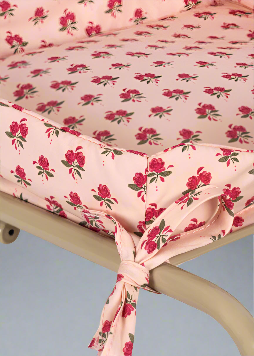 Premium fabric seat showing branded label accent and rose pattern detail on champagne wire basket frame