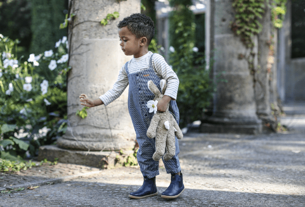 Toddler carrying large Senger beige rabbit companion showing attachment bond