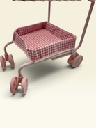 A pink toy shopping cart with a red and white gingham checkered cushion inside, shown on a plain light beige background.