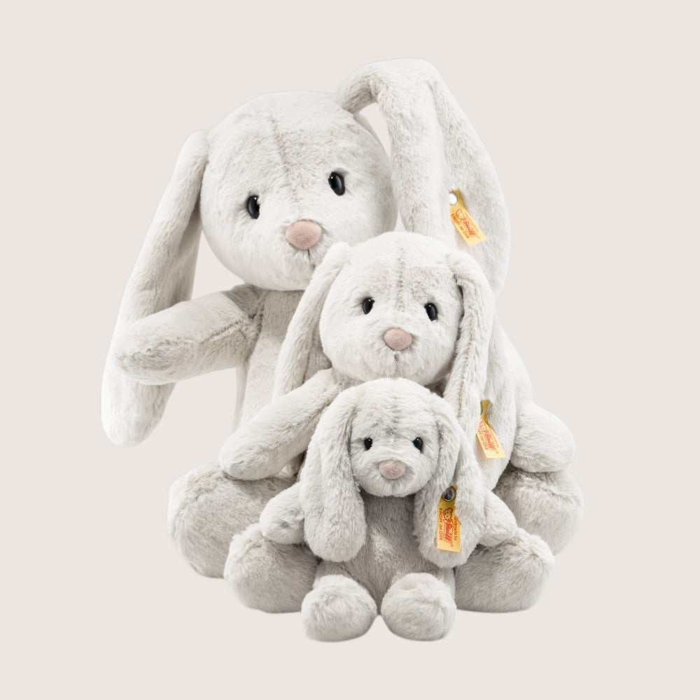 Three plush bunny toys of different sizes on a light gray background
