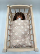 Taupe daisy doll bedding set with white flowers in wooden Bebenita doll cradle