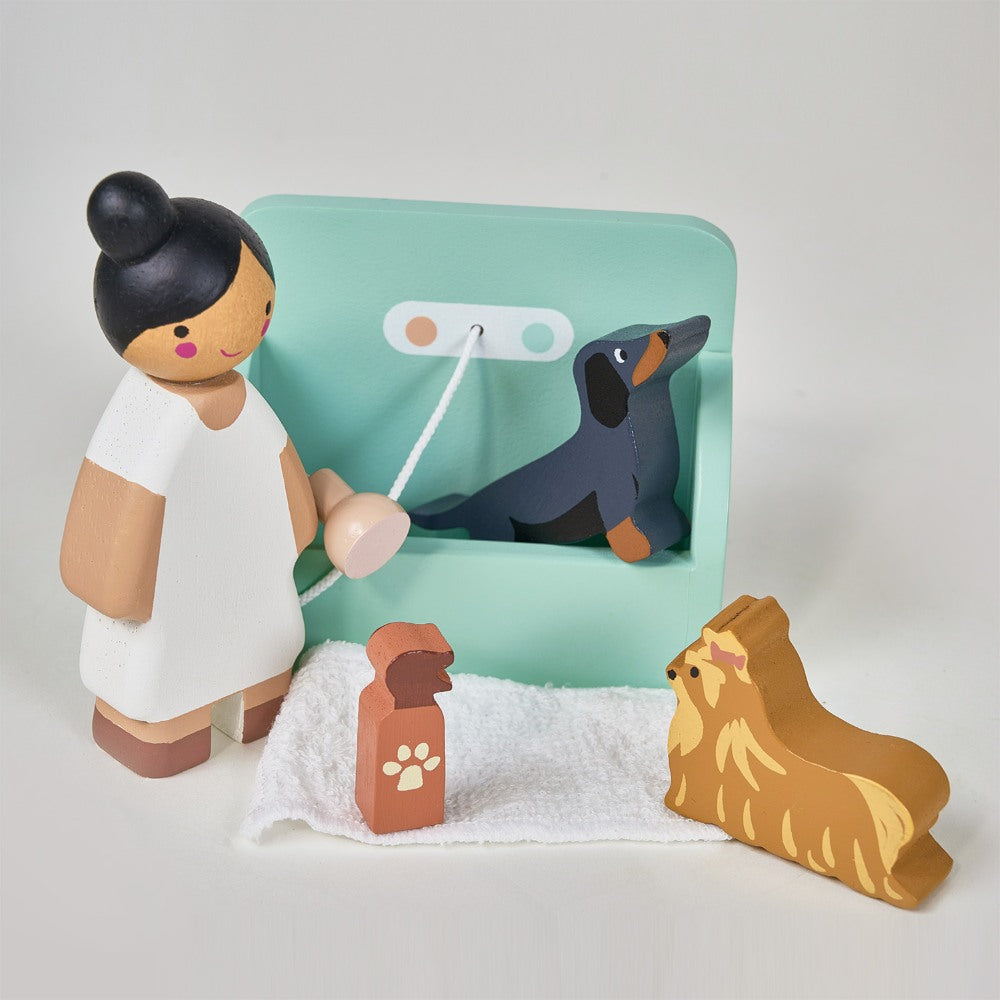 Wooden toy set with a girl, dog, and accessories on a light gray background