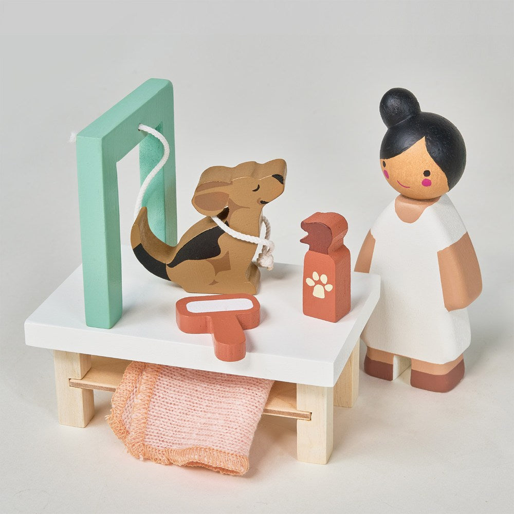 Wooden toy set with a dog, vet, and medical tools on a white surface