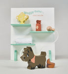 Wooden dog toy in front of a miniature dog salon set on a white background