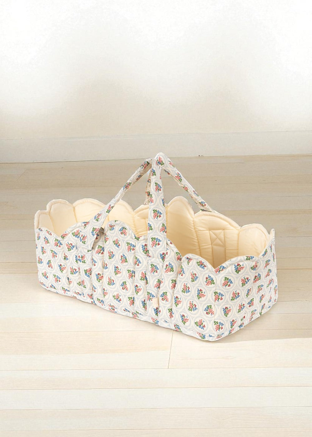 Verona Blues doll bassinet with Italian-inspired floral print, blue bouquets and cream quilted interior lining