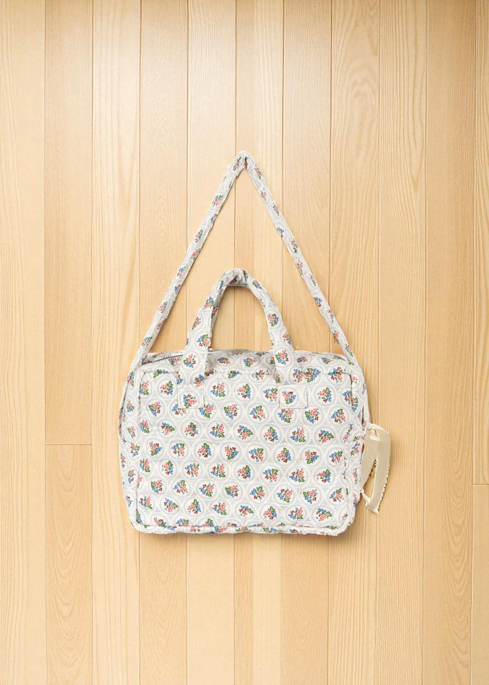 Doll diaper bag showing dual padded handles and adjustable crossbody strap for pretend play