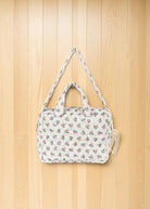 Doll diaper bag showing dual padded handles and adjustable crossbody strap for pretend play