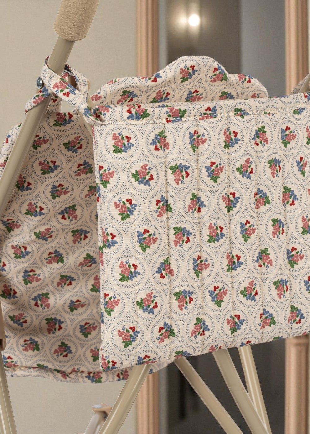 Romantic floral print detail showing coral and teal roses on padded doll stroller seat